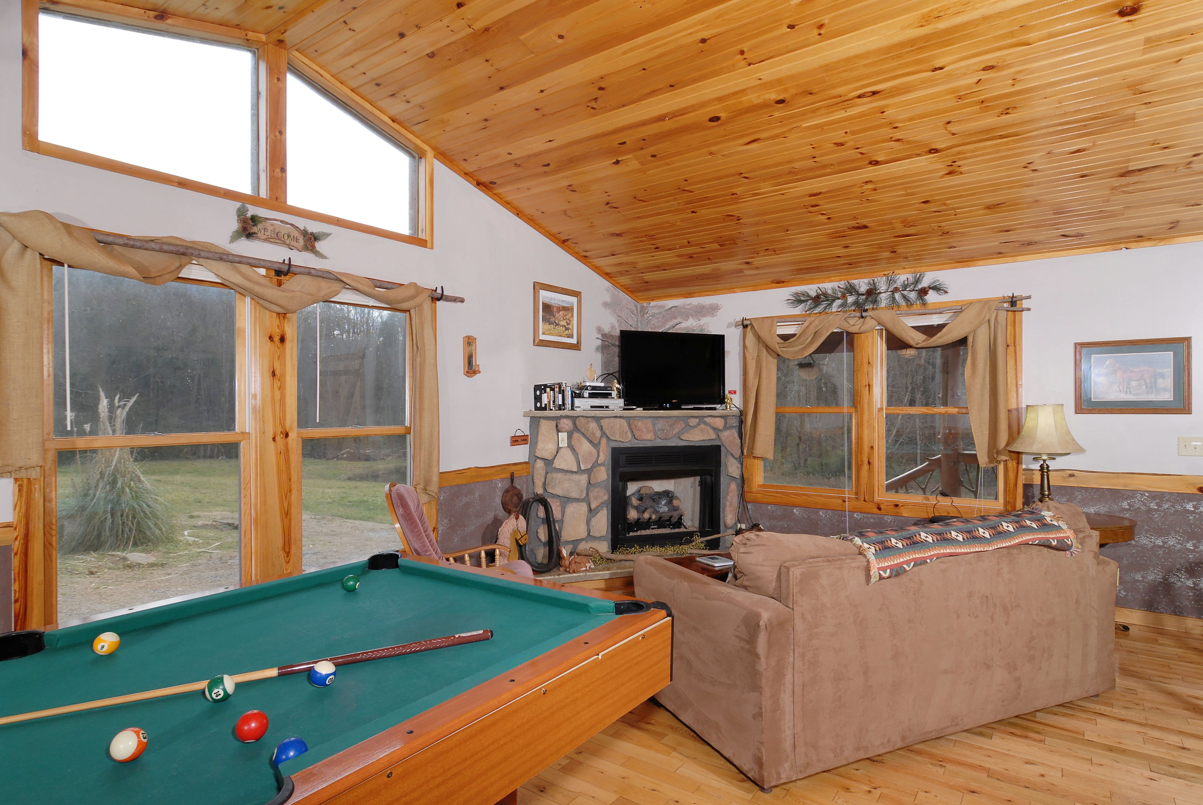Pigeon Forge One Bedroom Cabin with a pool table that over looks the living room area in a Smoky Mountain Cabin off of Wears Valley Road